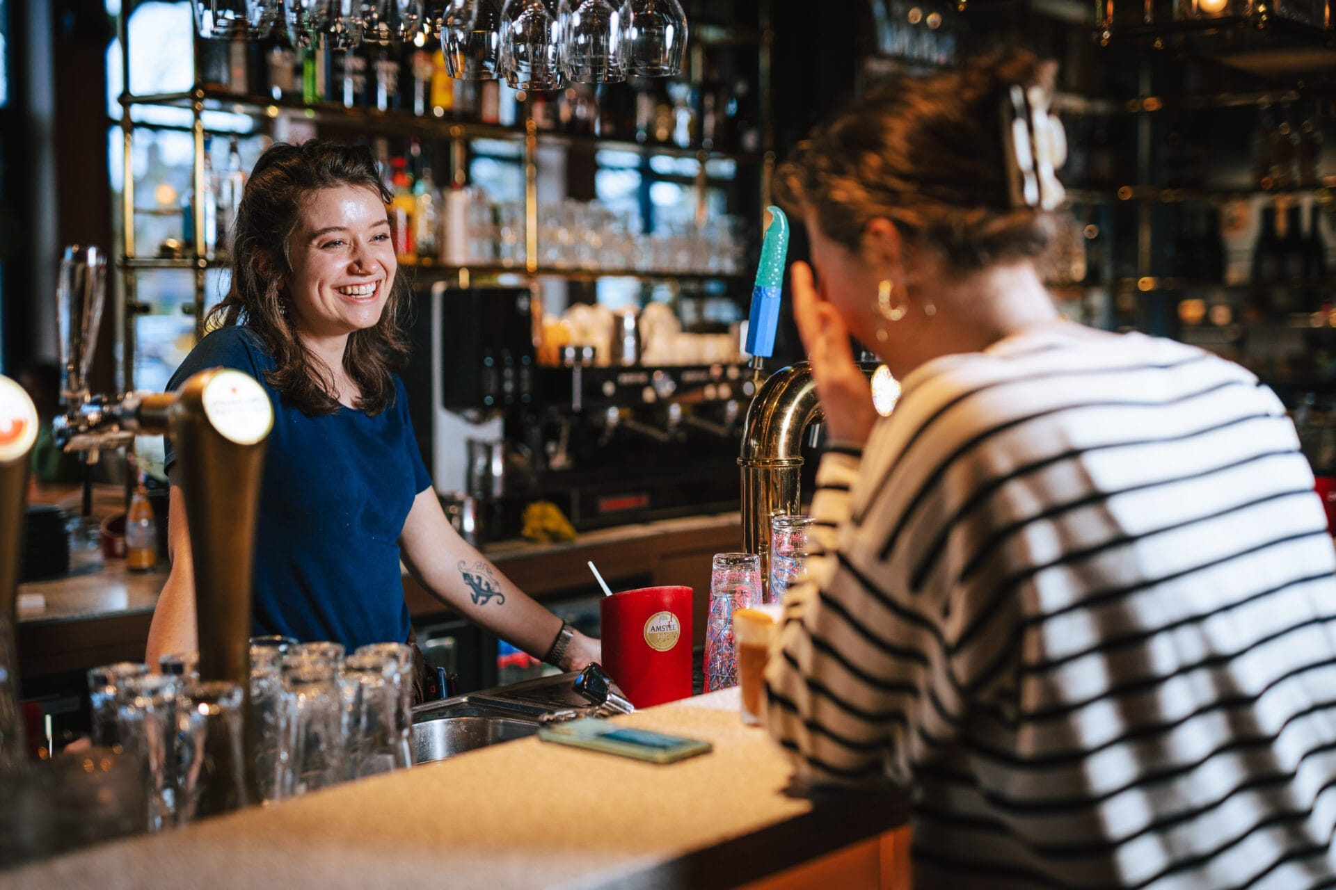 Floormanager achter de bar bij Buurten in de Gaard